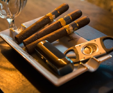 Cigars and a glass of wine on a tray - a sophisticated arrangement for indulging in relaxation and luxury.