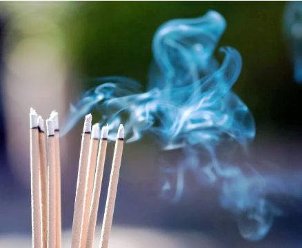 a group of incense sticks with smoke coming out of them